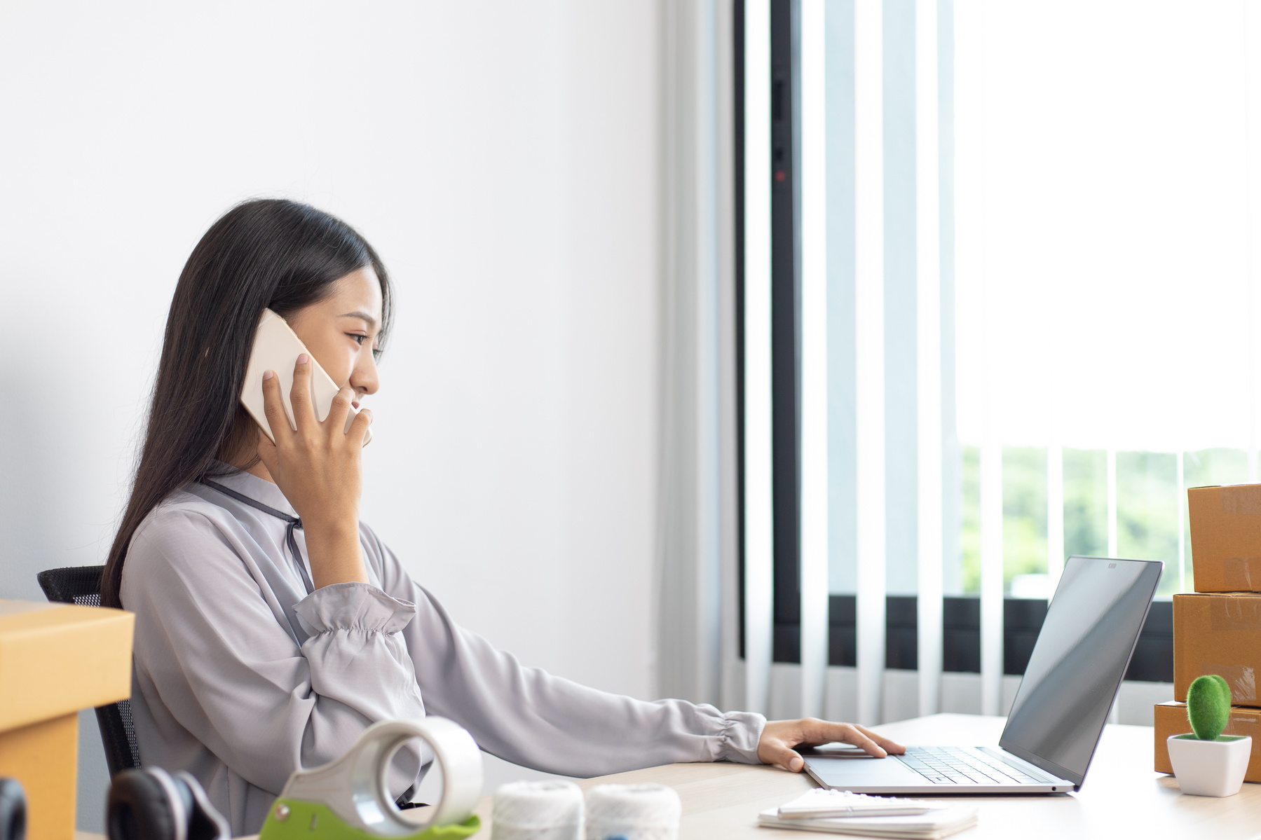 Young Businesswoman Talking on the Phone while Working 